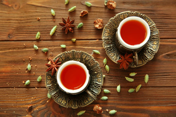 Two vintage cups of tea on wooden background, top view