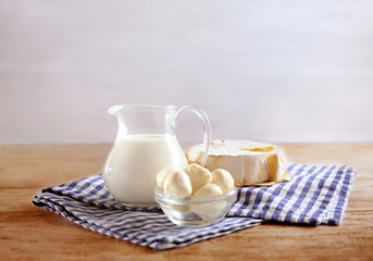 Fresh dairy products and napkin on table and light background