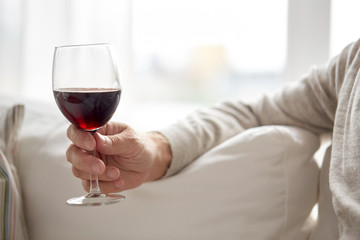 close up of hand holding glass with red wine