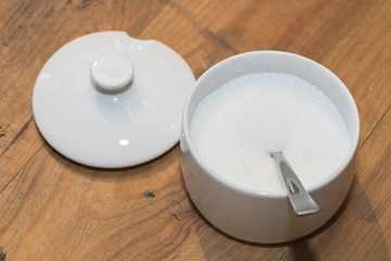 White sugar in glass bowl with teaspoon
