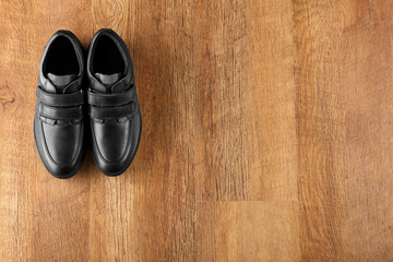 Fototapeta na wymiar Black shoes on wooden background