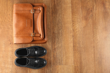 Black shoes and leather bag on wooden background