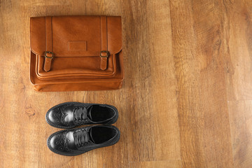 Black shoes and leather bag on wooden background