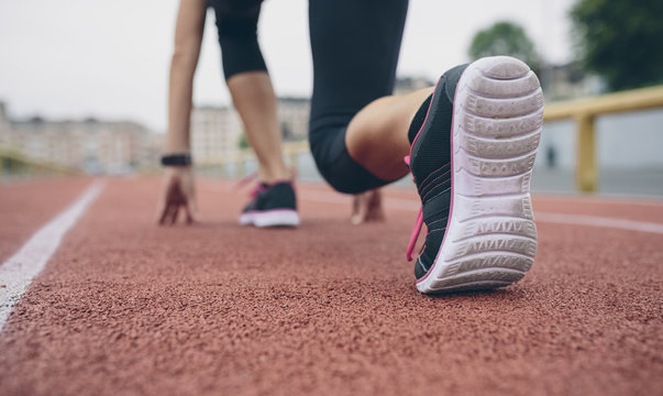 Woman on tartan track in starting position