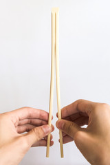 Hand Splitting Wooden Chopsticks on white Background