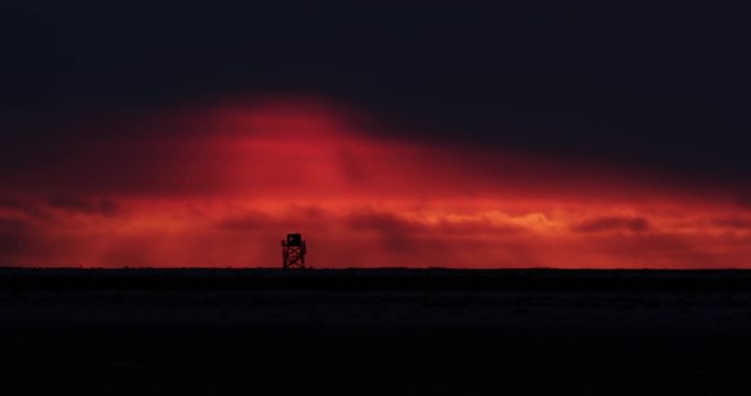 Time lapse - tower against red sky sunset with clouds medium