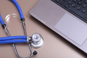 Blue stethoscope on a dark laptop computer