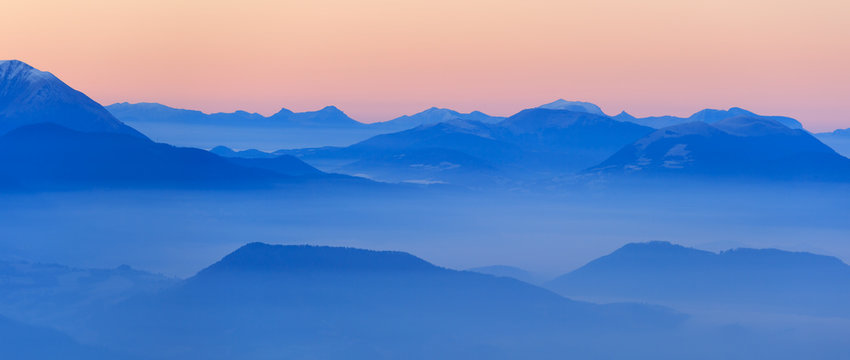 Colorful dawn in the French mountains, with the valley filled with fog.