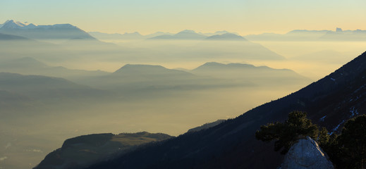 Colorful dusk in the French mountains, with the valley filled with fog.