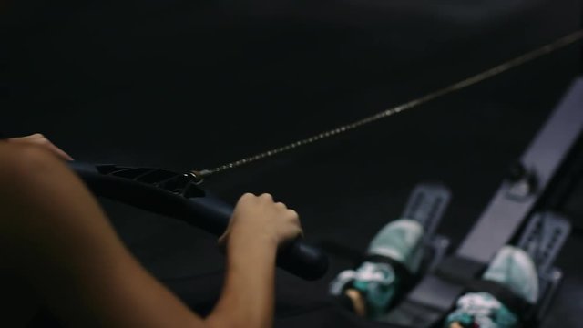 Beautiful girl athlete doing rowing crossfit exercises at the gym. Closeup hand