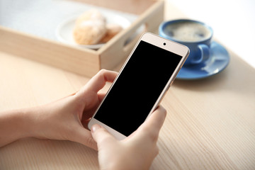 Woman with modern cellphone at table