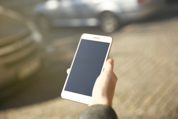 Woman holding modern cellphone, outdoor