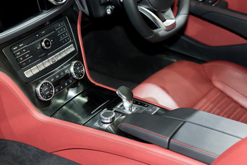 Obraz na płótnie Canvas Red luxury car Interior with steering wheel, shift lever and air