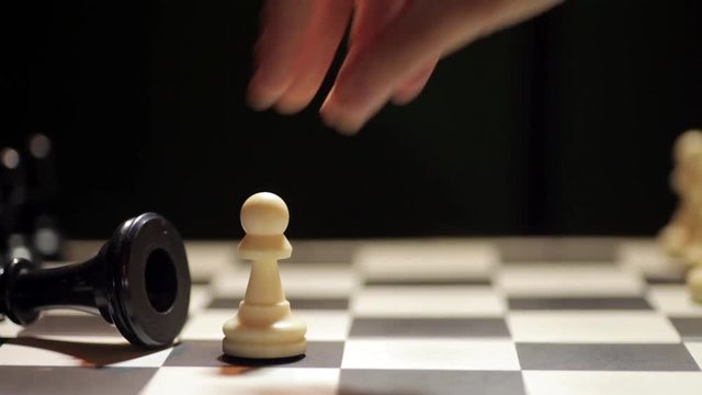 Shot of a chess board, with white pawn conquering the black king.