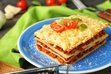 Plate with tasty lasagna on napkin, closeup