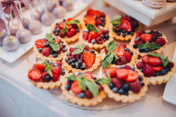 sweet bar with muffins cakes and sweets in area of wedding party