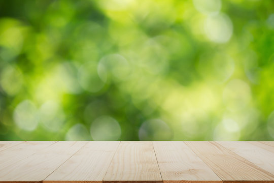 Wooden table top on blurred green bokeh background