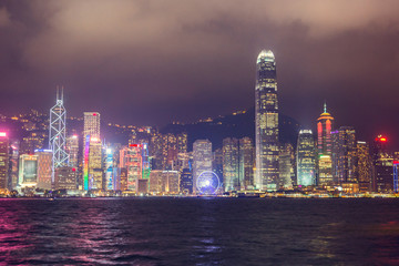 Skyline night view of tall buildings from across Victoria Harbor