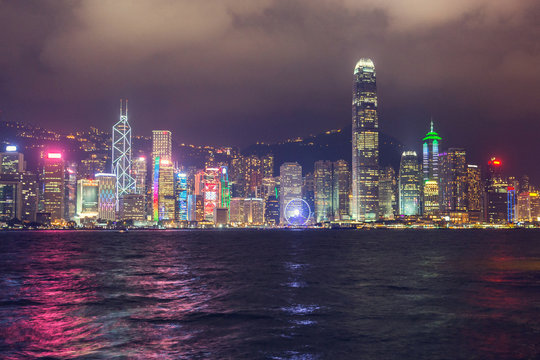 Skyline night view of tall buildings from across Victoria Harbor