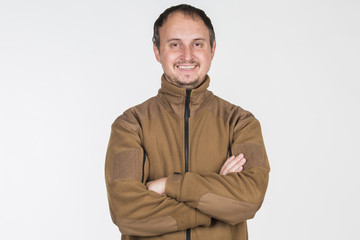 man in a brown jacket smiling on a white background
