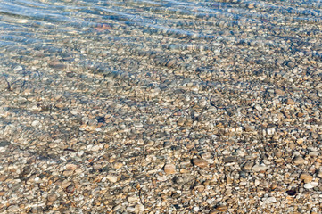 Natural background texture of river bottom with many little stones and small ripple