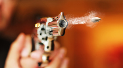 hand gun revolver with flying bullet fire - obrazy, fototapety, plakaty