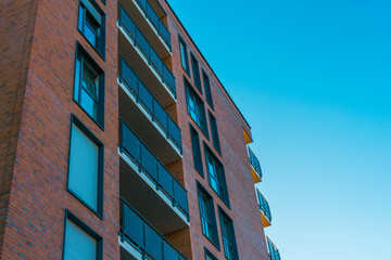 beautiful orange brick building with blue windows and sky