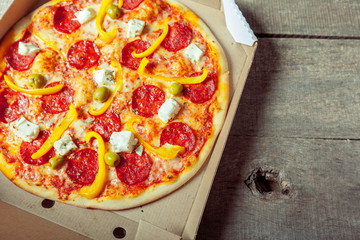 Fresh tasty pizza on wooden background