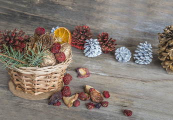Christmas composition/wicker basket with nuts,cones,fir branch,dry berries on rustic wooden background