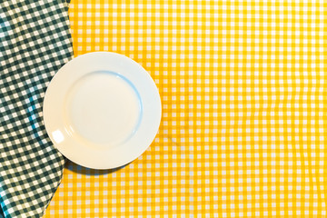 the plate on yellow checkered table cloth