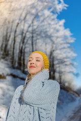 Beautiful young woman in her winter warm clothing. Happy woman h