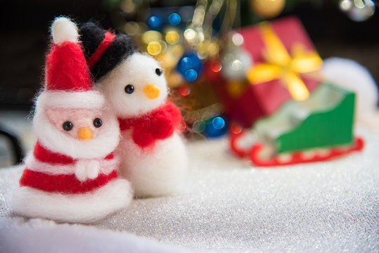 Santa claus and snowman wool doll on snow set up with xmas tree,
