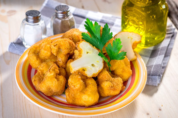 Breaded fried cauliflower on wooden background