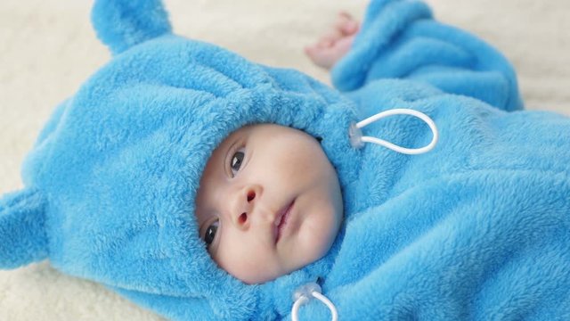 Cute 2-month-old baby boy. Baby in a funny dress of a toy bear cub.