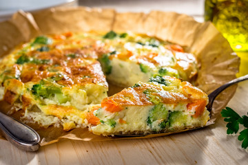 Homemade vegetable  quiche on wooden background