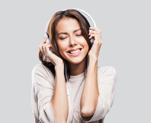 Emotional beautiful young woman with headphones listening to music