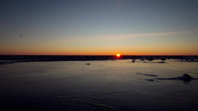 Timelapse of setting sun over pond ice in arctic