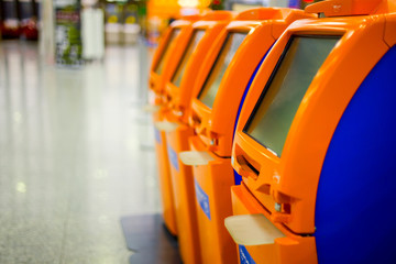 Terminals for self check-in standing in row at airport.