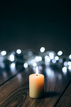Burning candle on a table with Christmas decorations