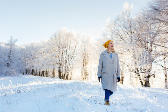 Image of pretty woman walking in snowy mountains. Portrait of fe