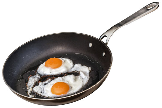 Sunny Side Up Eggs Fried In Old Heavy Duty Steel Frying Pan Isolated On White Background