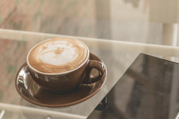 A cup of coffee latte on the table in coffee shop, Vintage filter effect.