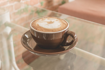 A cup of coffee latte on the table in coffee shop, Vintage filter effect.