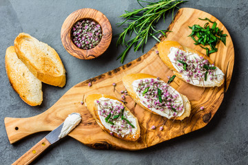 Sandwiches with cream cheese and garlic edible flowers, olive board
