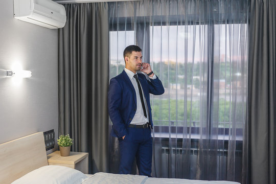Young businessman calling on the phone in his hotel room