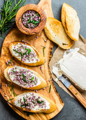 Obraz na płótnie Canvas Sandwiches with cream cheese and garlic edible flowers, olive board