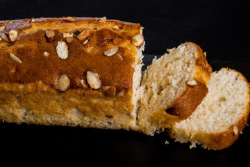 Almond cake, sliced, on black background