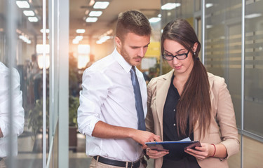 Businessman and businesswoman discussing work while walking