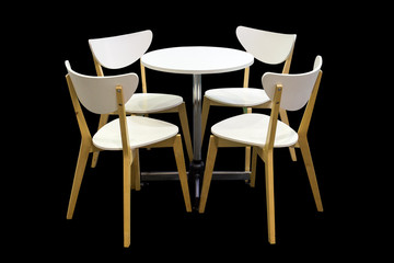 Wooden chairs and white table on black background.