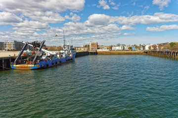 Fototapeta na wymiar Lonely boat floating on water in the Boston Harbor